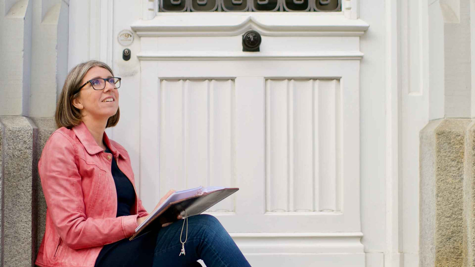 Julia auf einer Treppe sitzend und Tagebuch schreibend