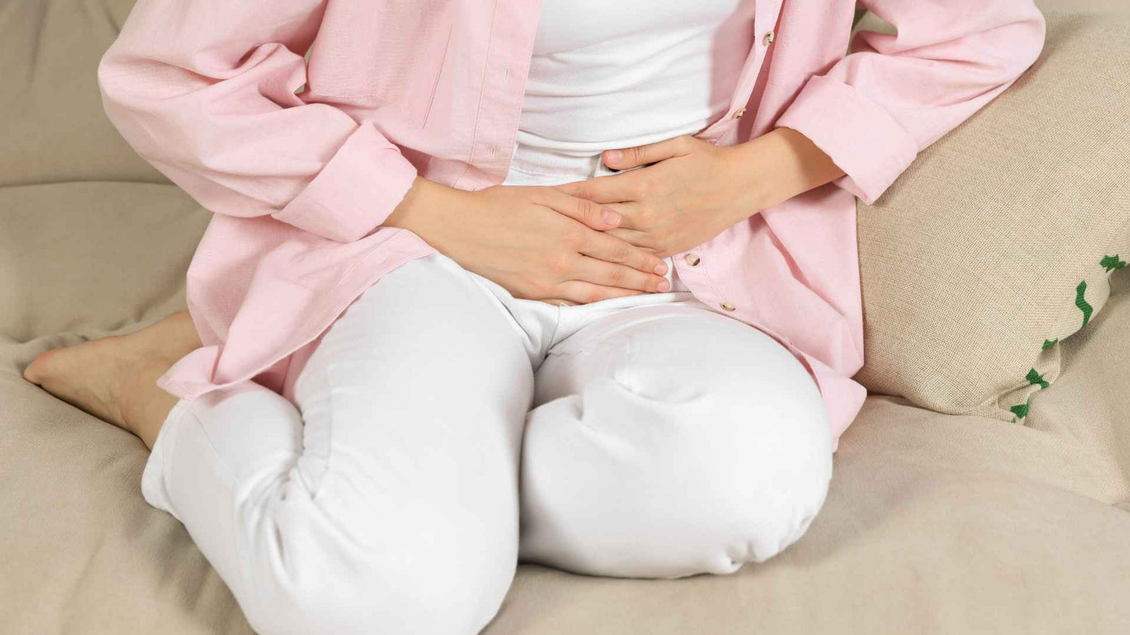 Frau die sich vor Schmerzen den Unterbauch hält