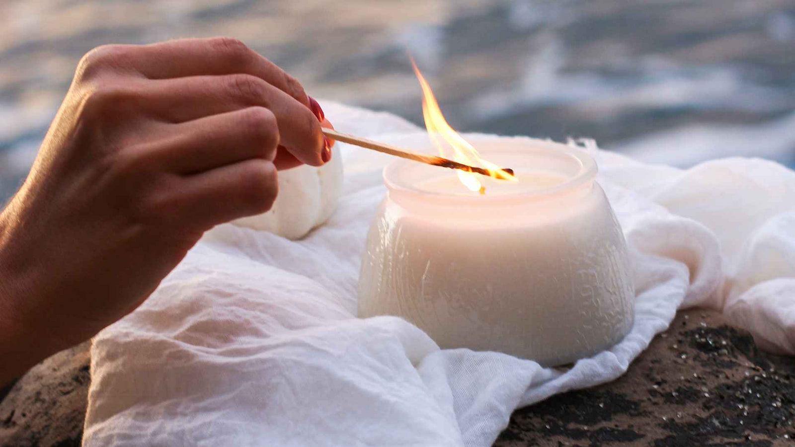 Hand die eine Kerze mit Streichholz anzündet