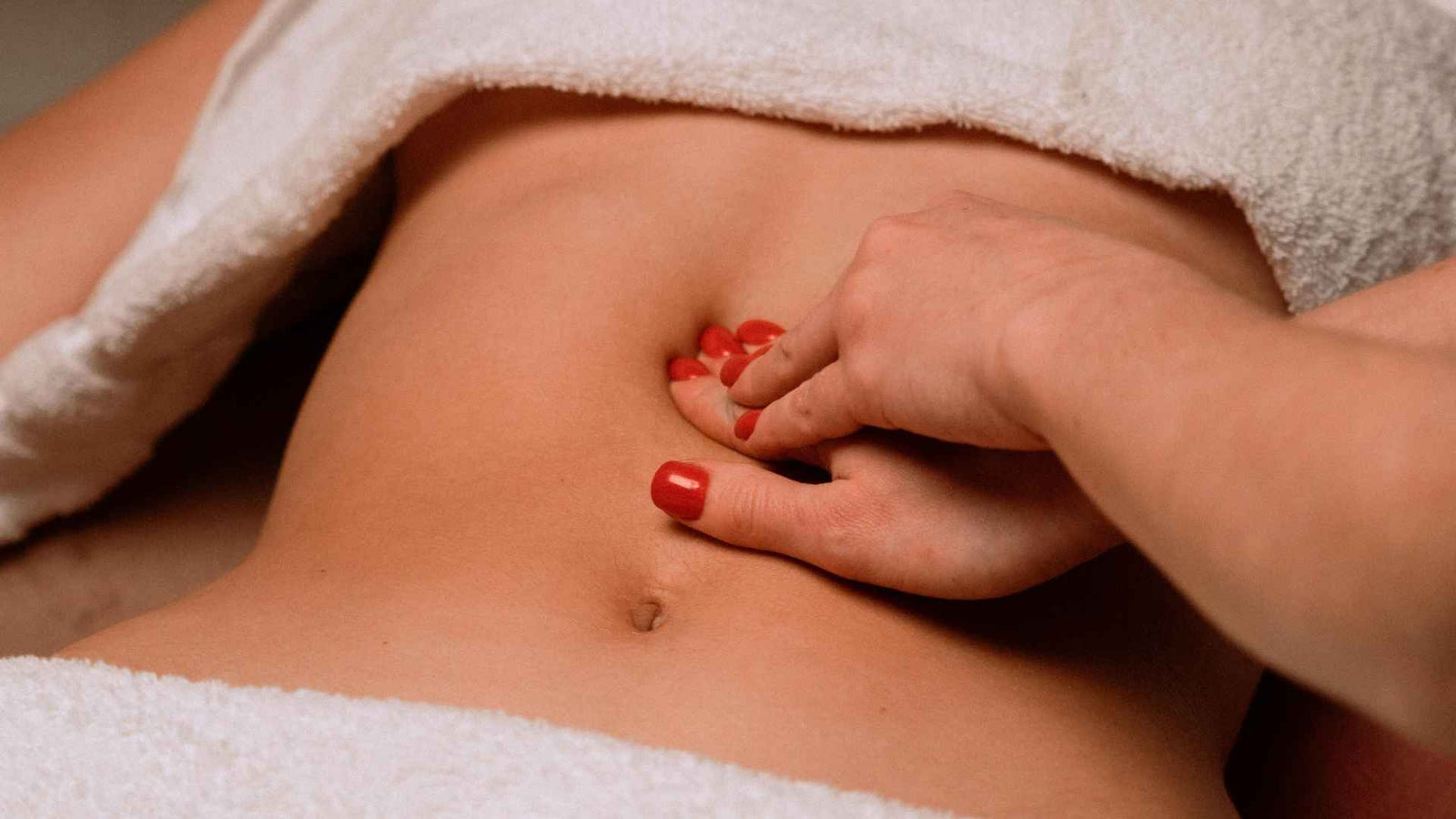 Frauenhände, die eine Bauchmassage durchführen