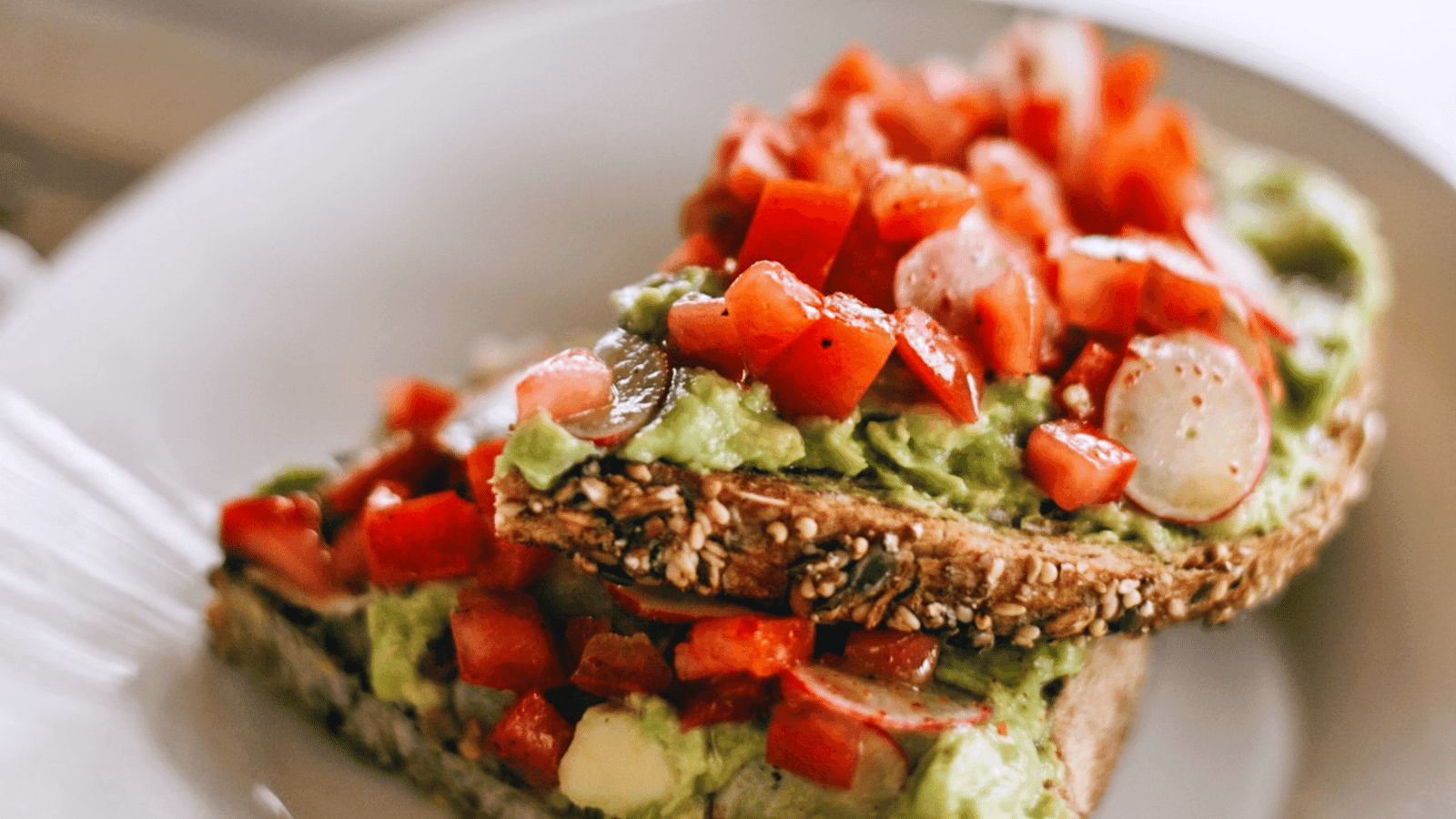 Brot mit Tomate und Avocado auf weissem Teller