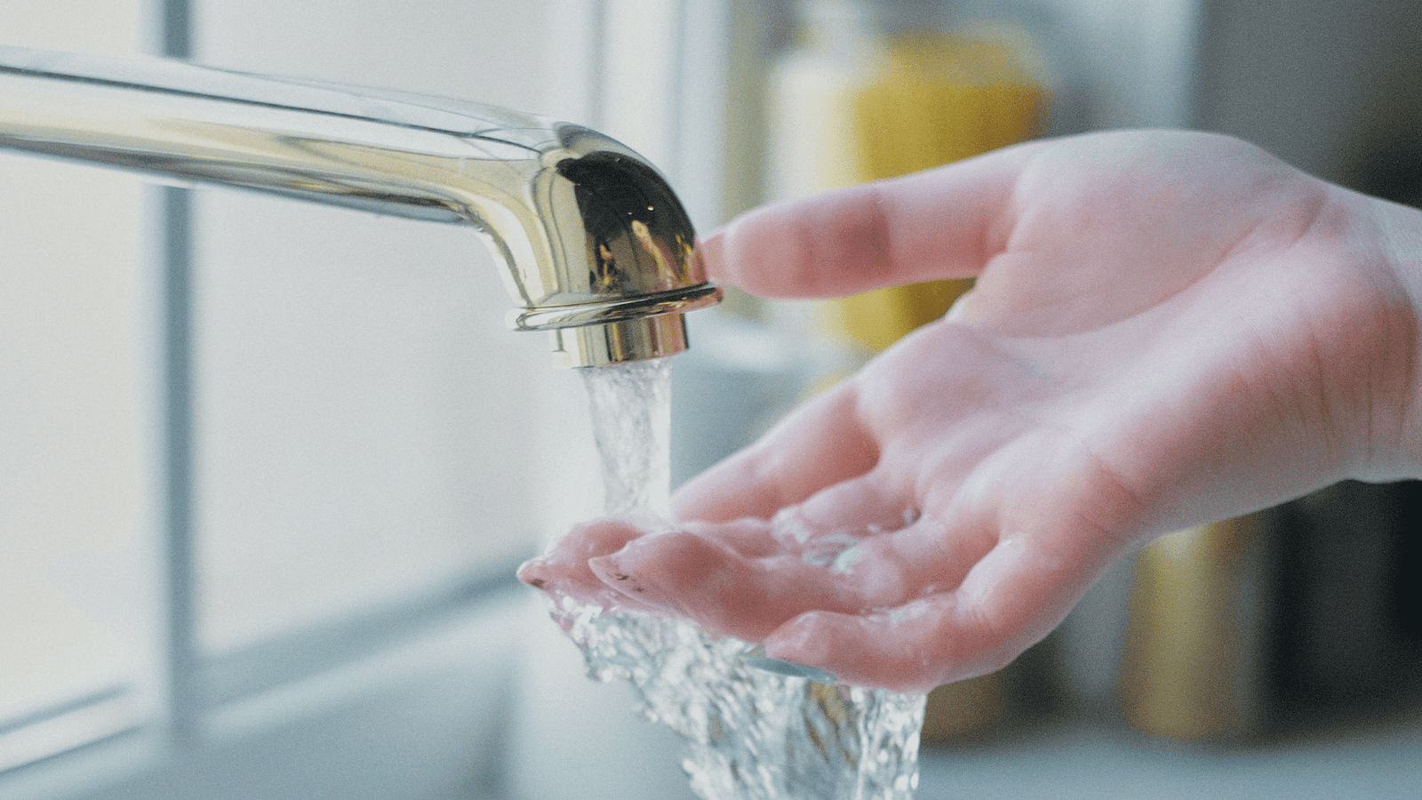 wie gesund ist unser leitungswasser wasser läuft aus goldenem wassserhahn frauenhand