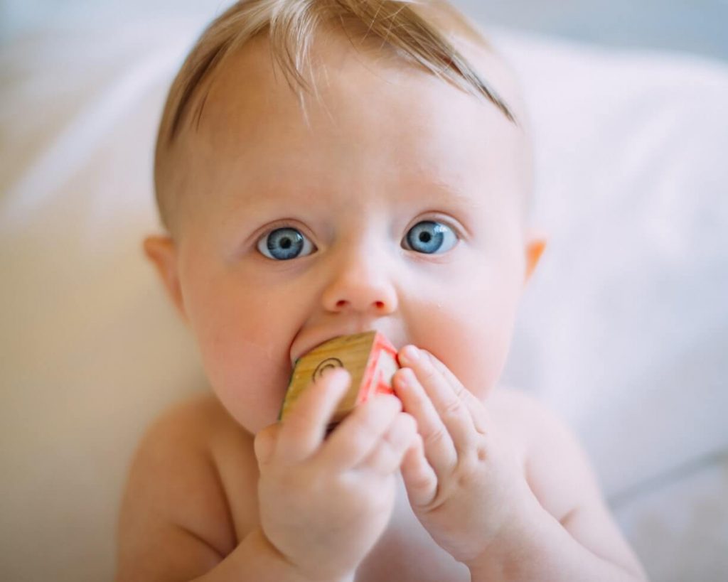 Baby mit blauen Augen spielt mit einem Spielzeug